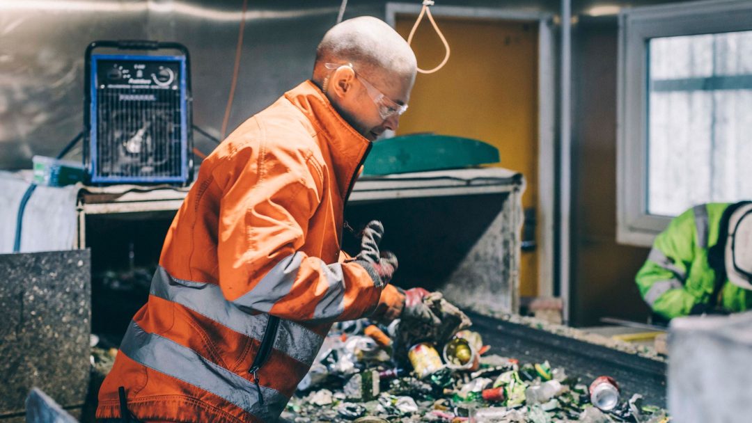 Bilde av arbeider som sorterer glass og metall.