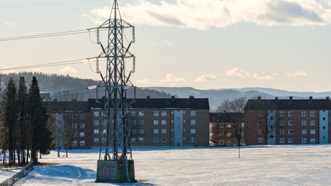 Et snødekt felt med kraftledninger i bakgrunnen, som viser energiforsyning.