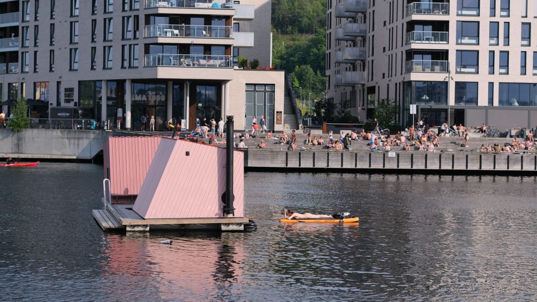 En rosa bygning flytende i vannet med solcelleanlegg.