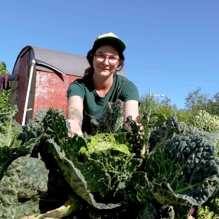 dame som viser frem kålplanter