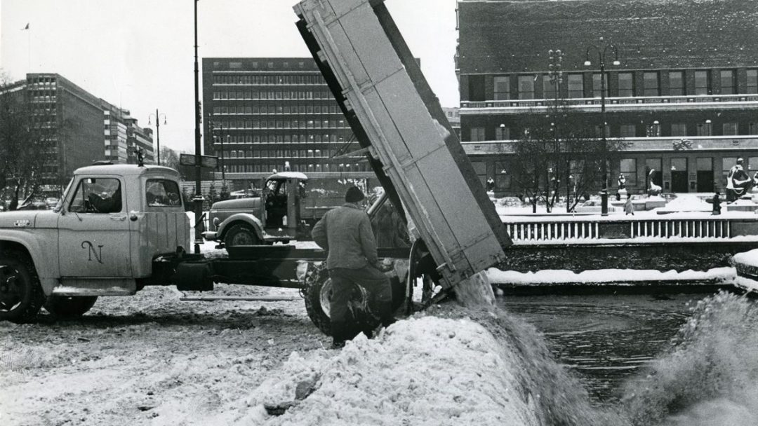 Eldre bilde av en lastebil som dumper snø i sjøen ved Rådhuset