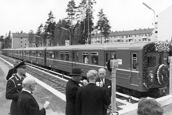 Svart-hvitt-bilde fra Bergkrystallen t-bane-stasjon. T-bane og folk som feirer åpningen.