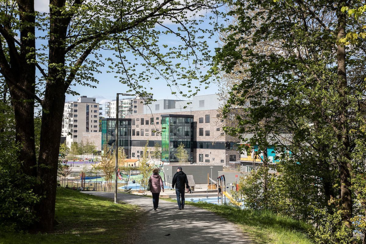 to personer som går igjennom en park i byen