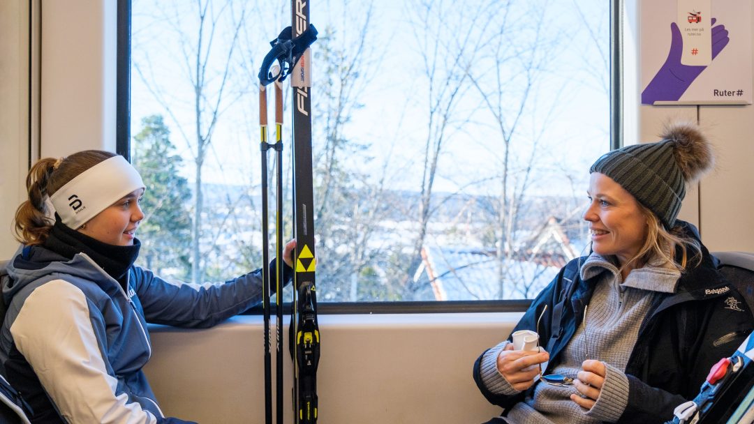 To kvinner med ski reiser kollektivt med t-bane