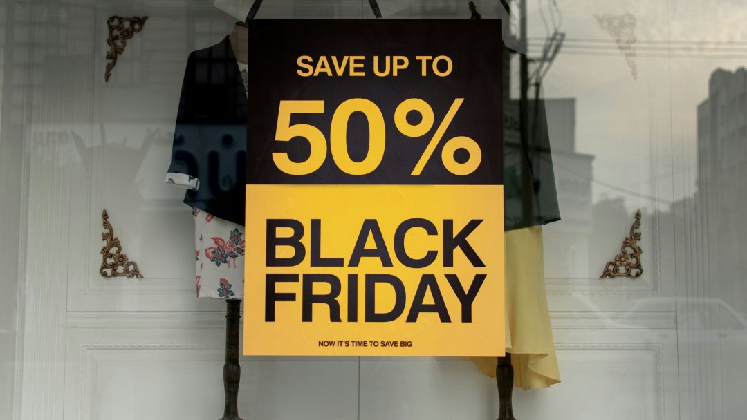 Butikkvindu med Black Friday-plakat. Plakaten viser at det er tilbud med 50% avslag.