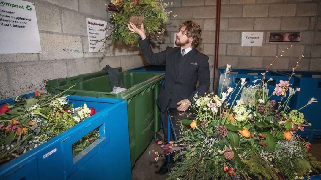 Gravferdskonsulent sortere og kaster blomster.