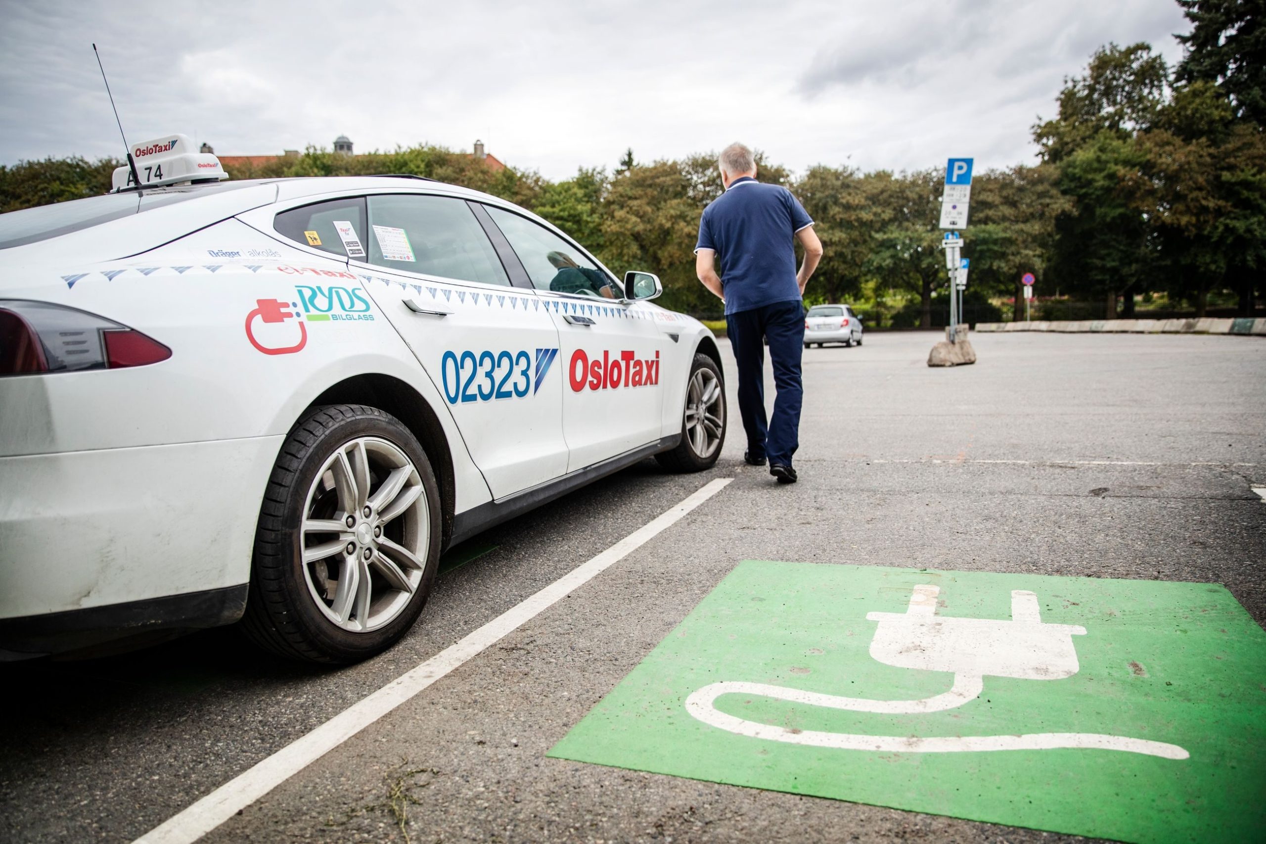 mann utenfor en taxi på en ladeplass