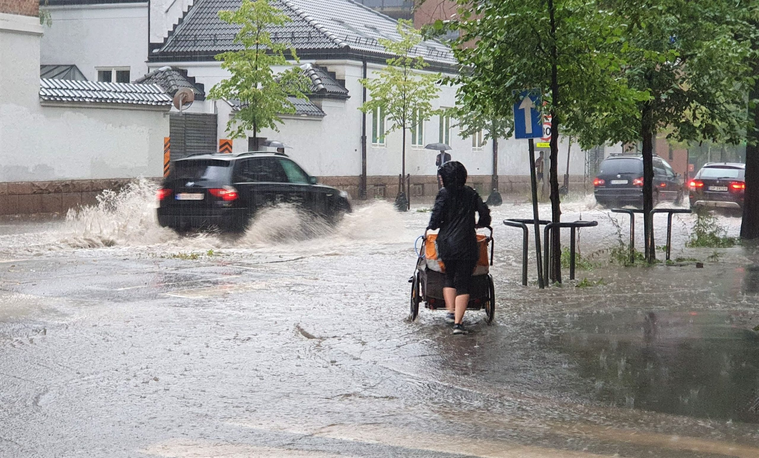 oversvømt vei, bil, dame med barnevogn