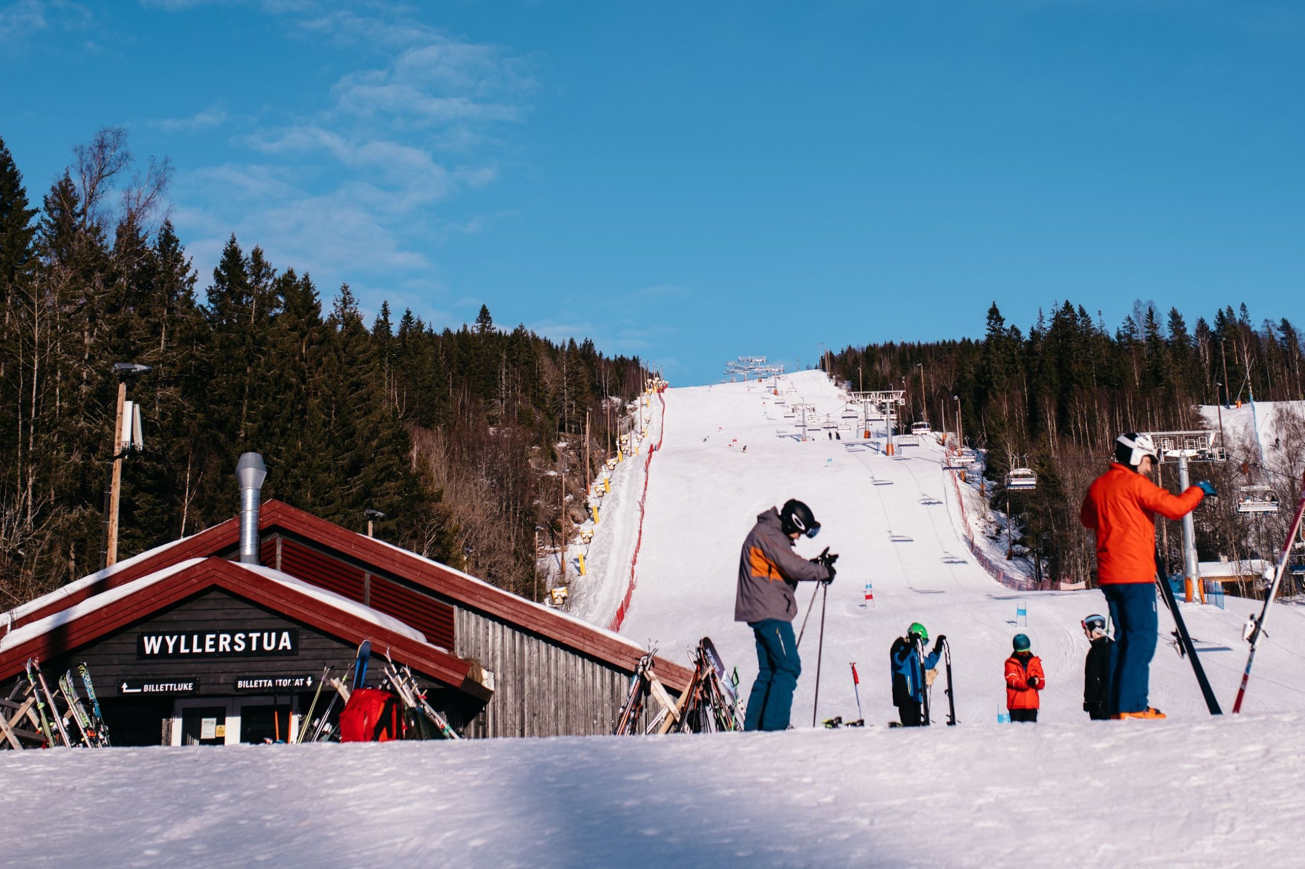 En gruppe mennesker som driver vinteraktiviteter på ski, glir grasiøst ned en snødekt skråning.