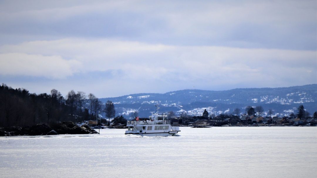 Ferry sailing on calm sea with beautiful scenery in the background