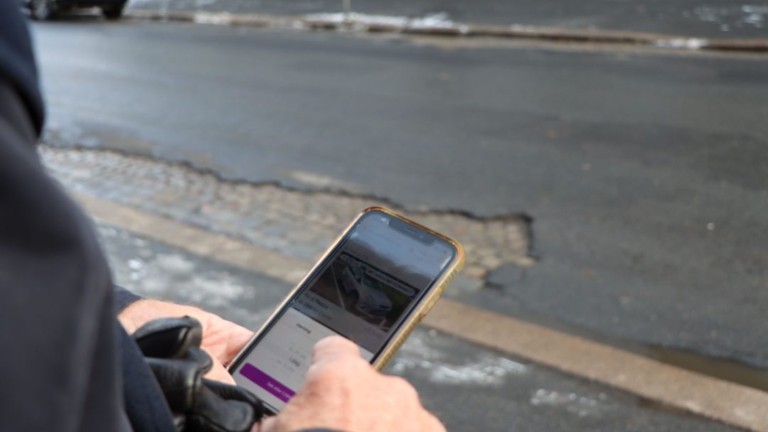 En mann trykker på mobilen sin.