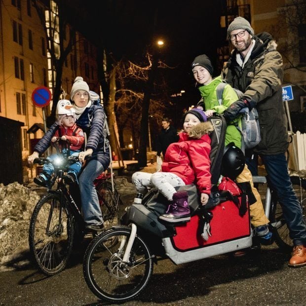 A family of two bikes. An electric bicycle loaded with both children and backpacks.