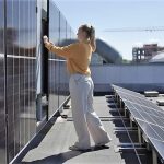kvinne sjekker vertikale solceller på tak