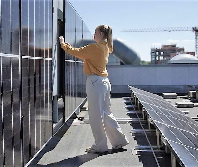 kvinne sjekker vertikale solceller på tak