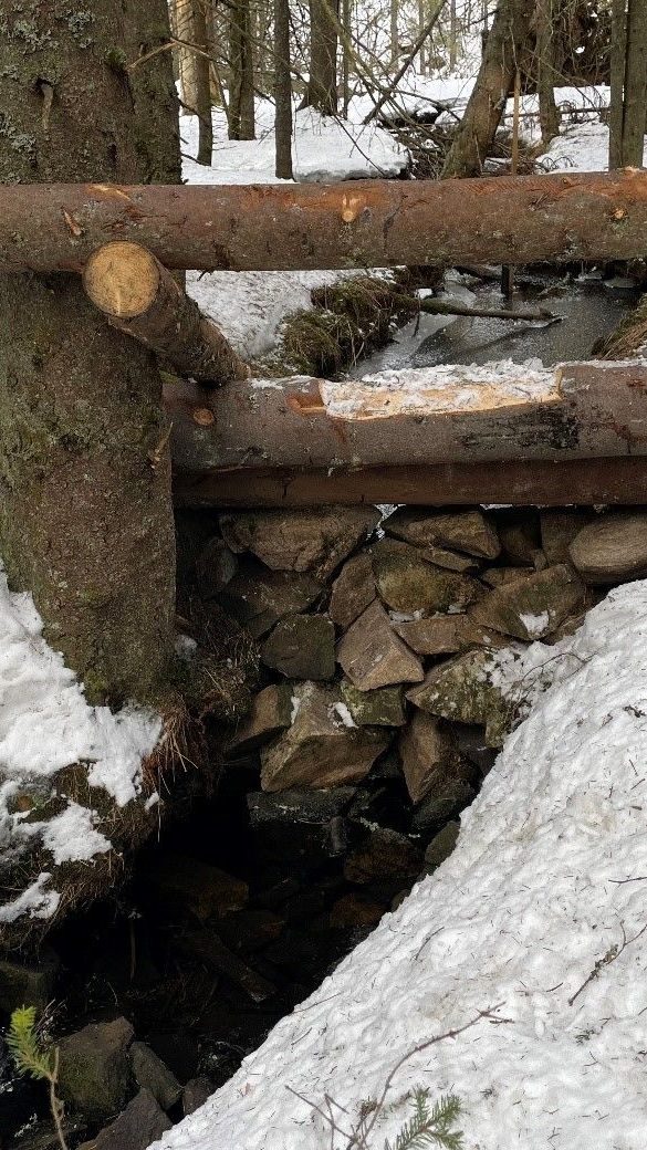 Trestokker som er lagt som en barriere i Lunnerdalen.