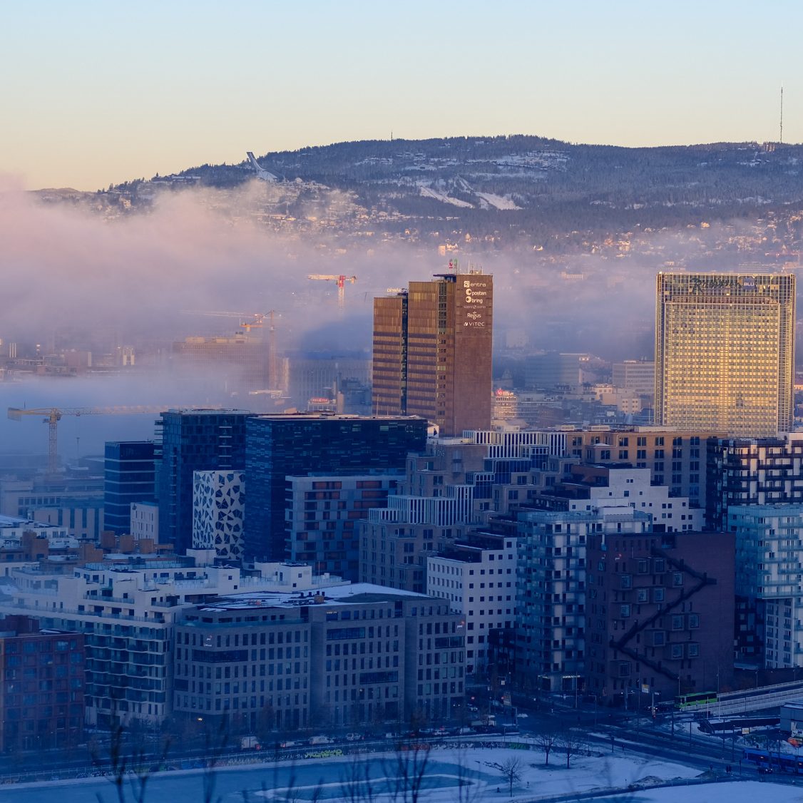 Panorama over Oslo med skyer og lavt sollys