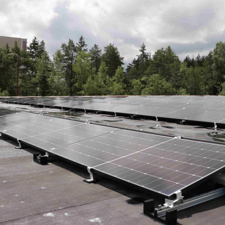 solceller som kan produsere solenergi på et garasjetak med trær og himmel bak