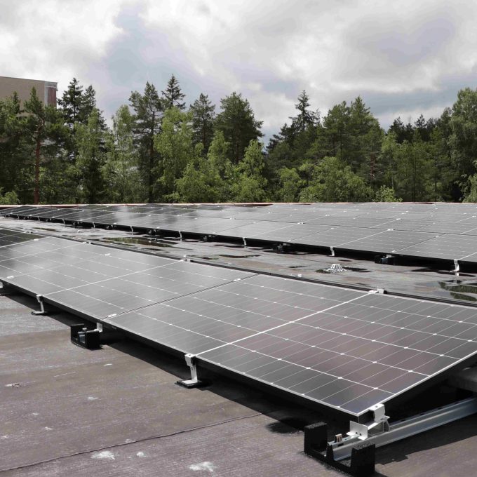 solceller som kan produsere solenergi på et garasjetak med trær og himmel bak