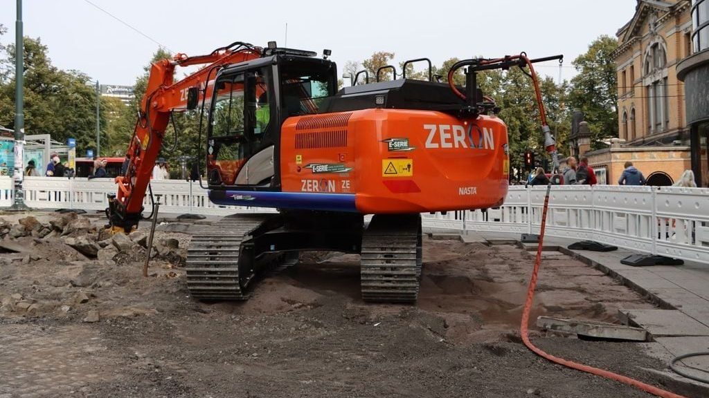 orange elgravemaskin på byggeplass