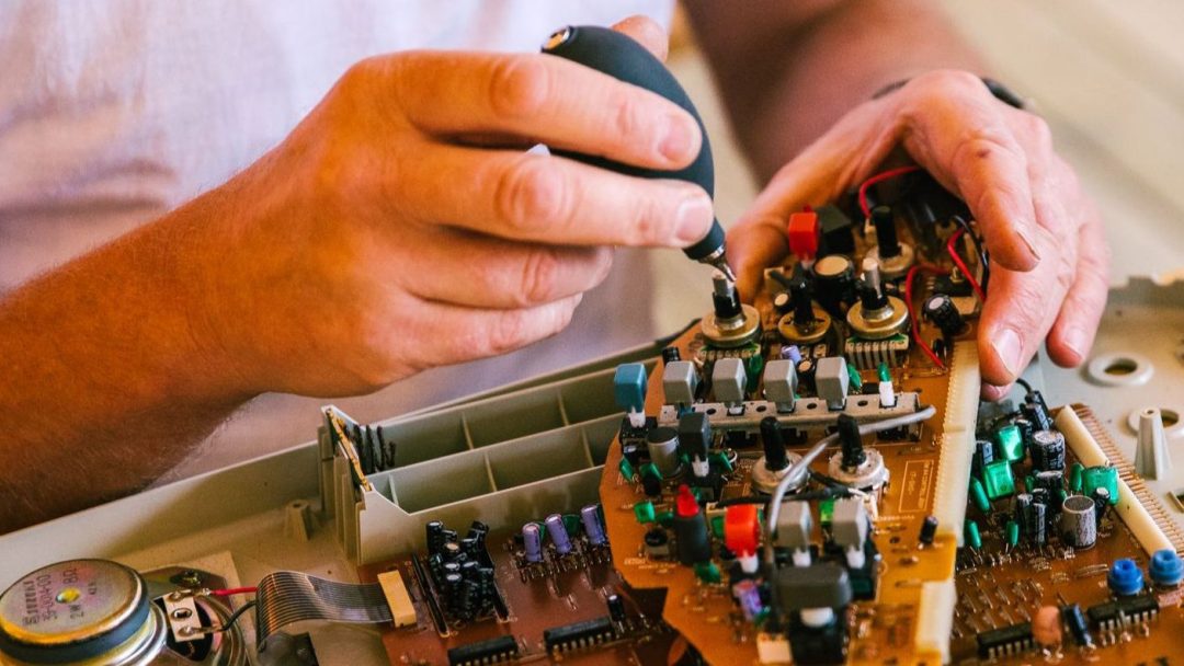 hender som reparerer elektronisk produkt