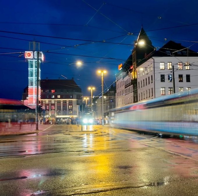 kveldsbilde fra jernbanetorget, en buss og en trikk i fart
