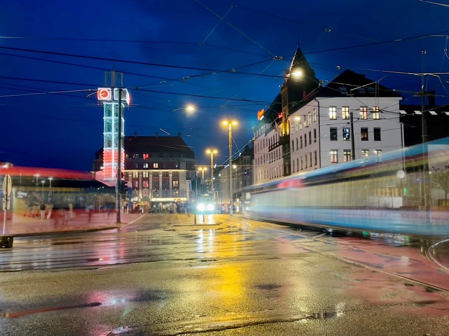 kveldsbilde fra jernbanetorget, en buss og en trikk i fart
