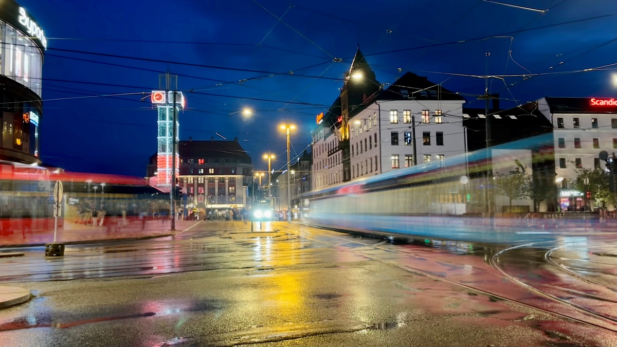 kveldsbilde fra jernbanetorget, en buss og en trikk i fart