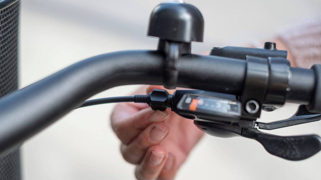 sykkelreparasjon i Oslo, hånd justerer girkabel under sykkelstyre